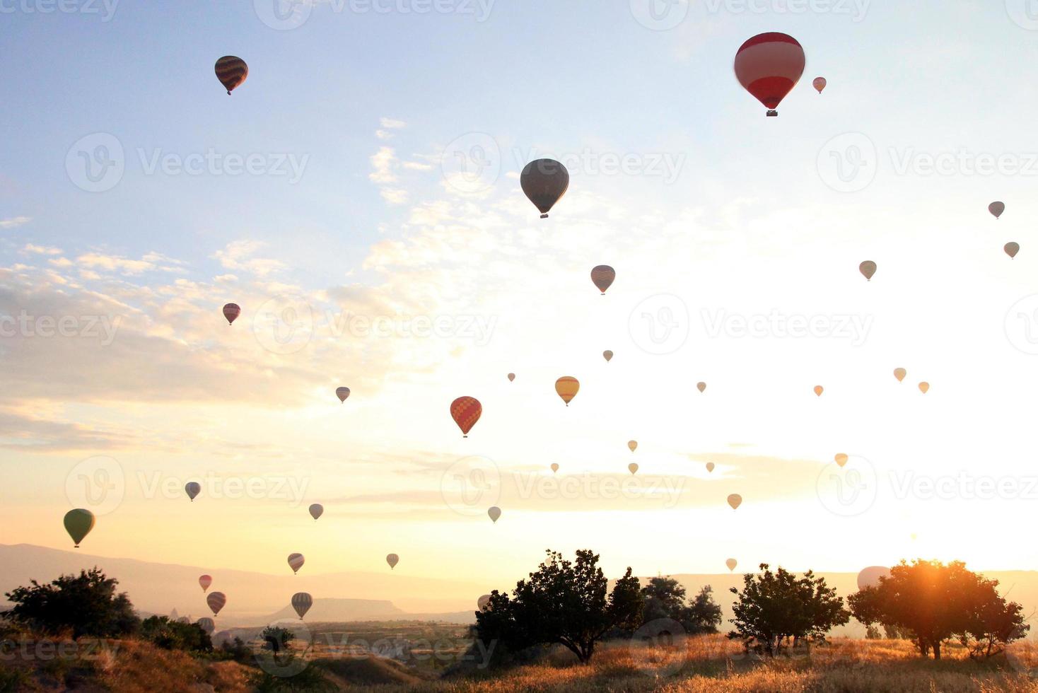 reise nach göreme, kappadokien, türkei. der sonnenaufgang in den bergen mit viel luft heißluftballons am himmel. foto