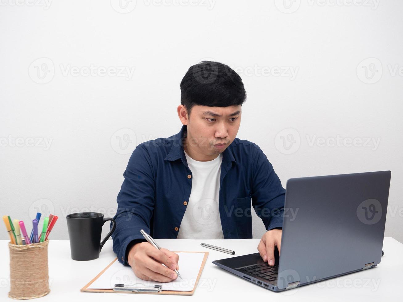 Arbeiter Mann sitzt am Büroarbeitsplatz ernste Emotionen mit Laptop auf dem Tisch foto