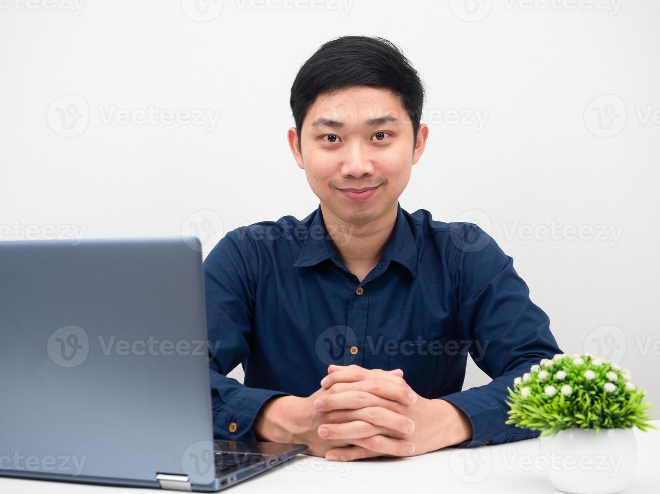 Gutaussehender Mann, der selbstbewusst am Tisch mit Laptop-Arbeitsplatz sitzt foto