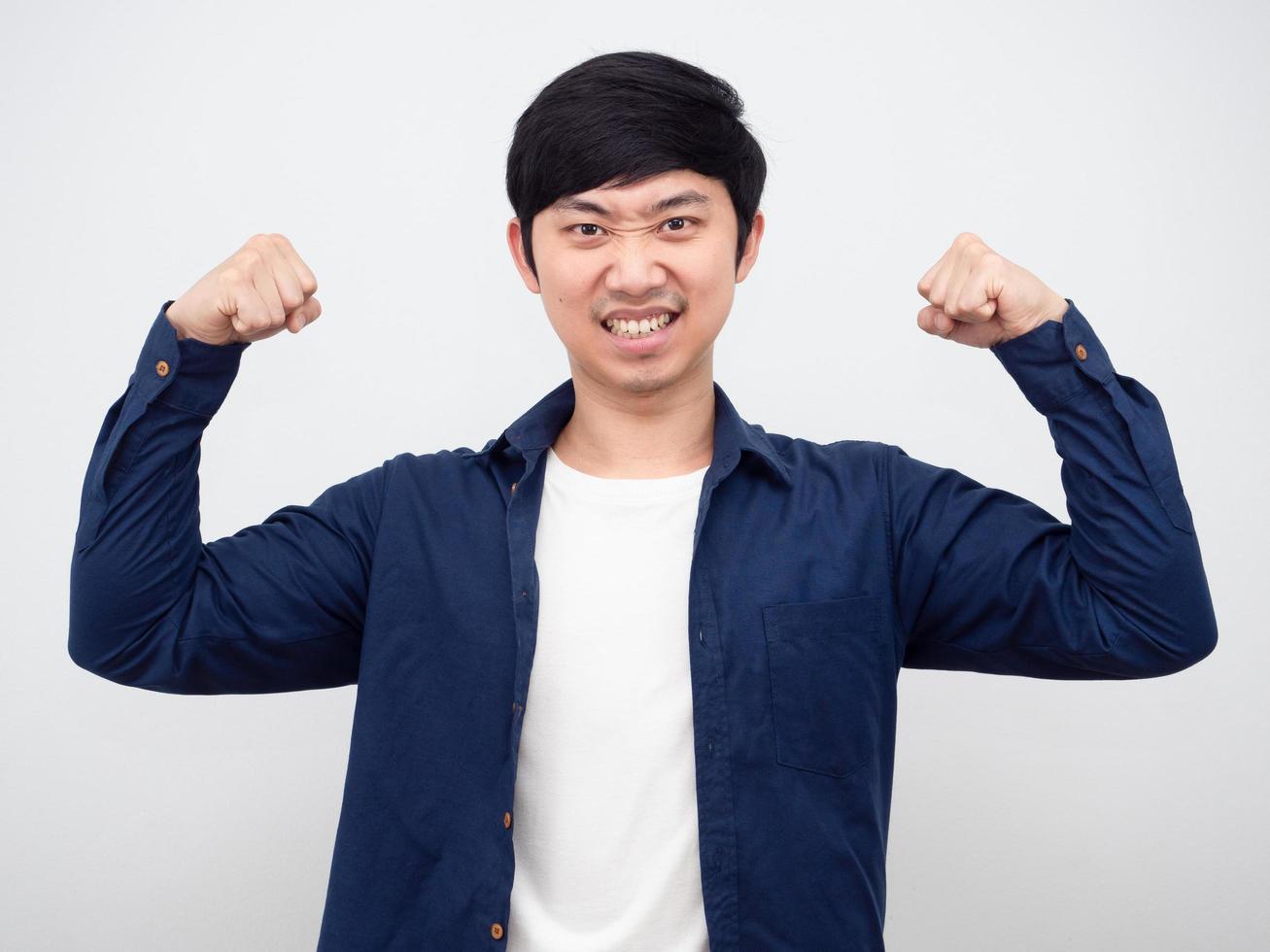 asiatischer mann zeigt muskeln fröhliches gesicht blick geschäftsmann weißer hintergrund porträt foto