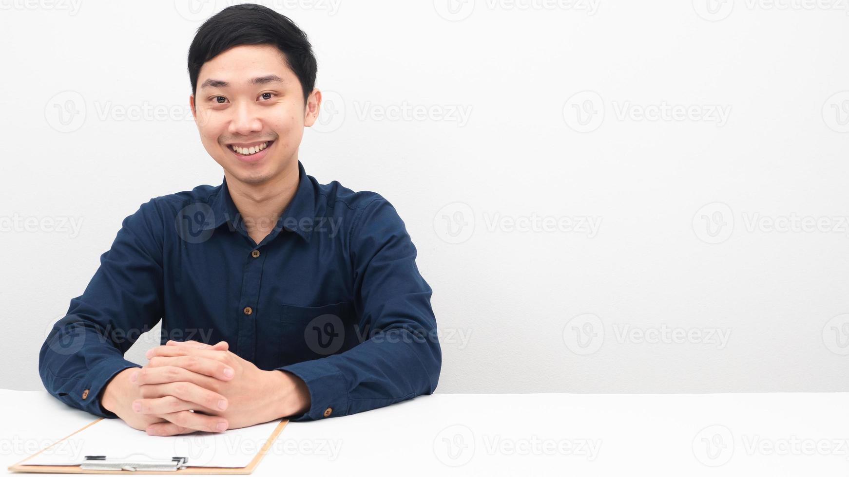 Mann sitzt am Tisch glücklich und lächelt Kopie Raum weißen Hintergrund foto