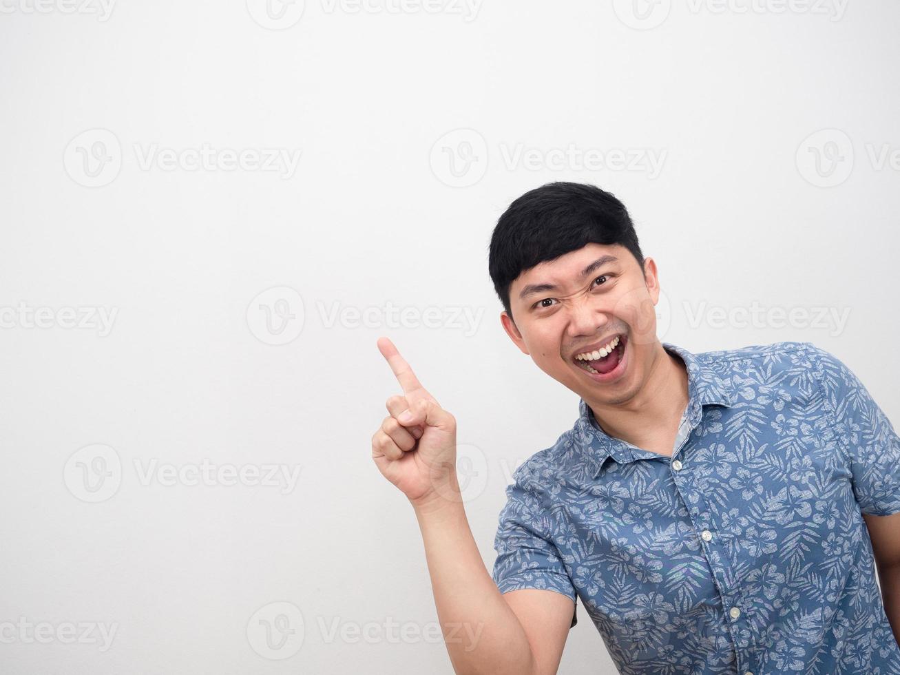blaues hemd des asiatischen mannes, das sich erstaunt fühlt, zeigt mit dem finger auf den kopierraum foto