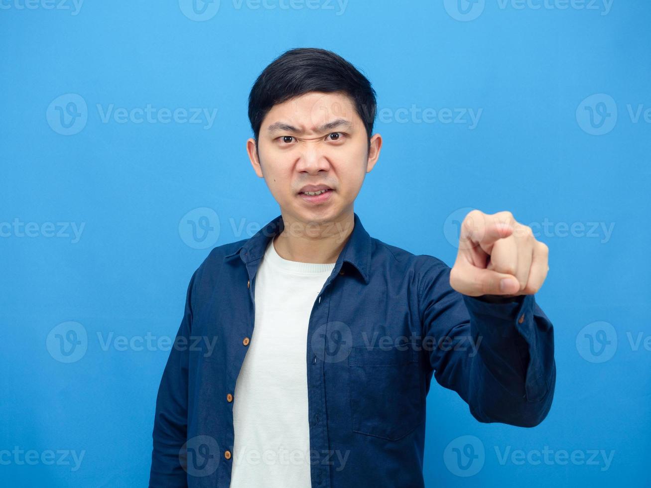 Mann wütendes Gesicht zeigt mit dem Finger auf Sie blauer Hintergrund foto