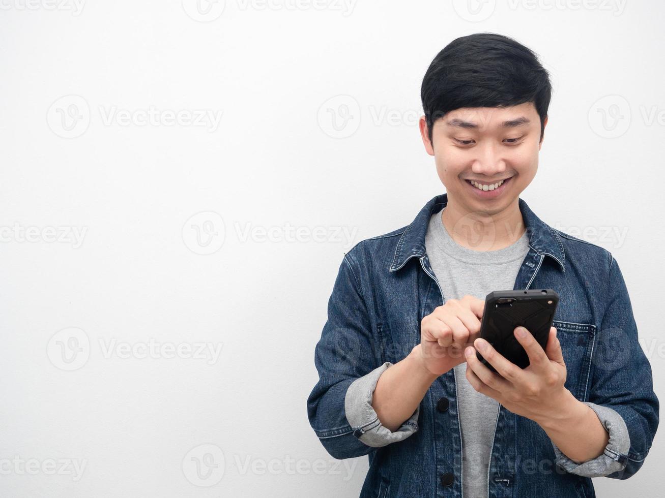 fröhlicher Mann Jeans Anzug mit Handy Kopie Raum weißen Hintergrund foto