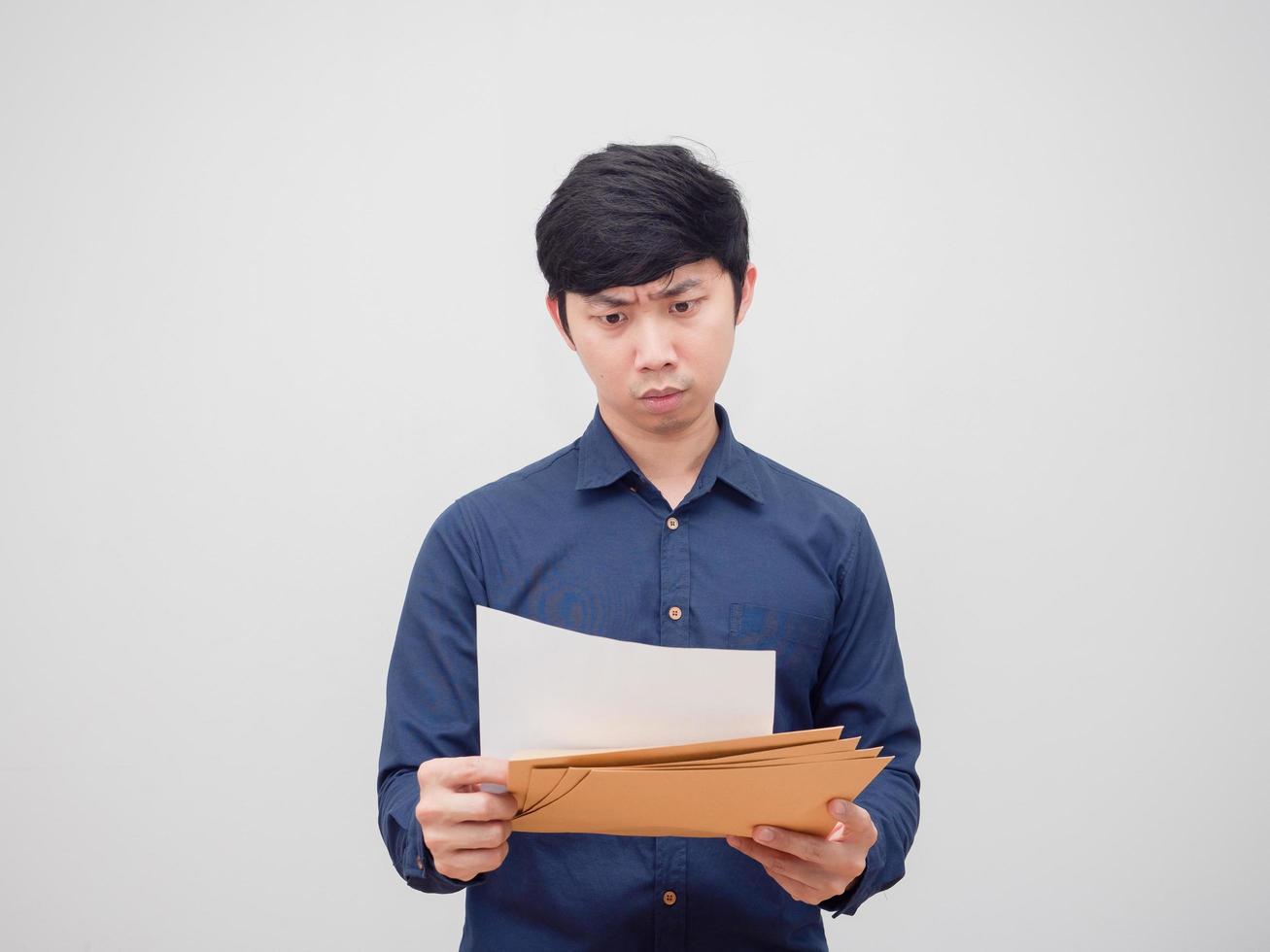 asiatischer Mann, der ein Dokument in seiner Hand liest und sich auf weißem Hintergrund anstrengt und anstrengt foto