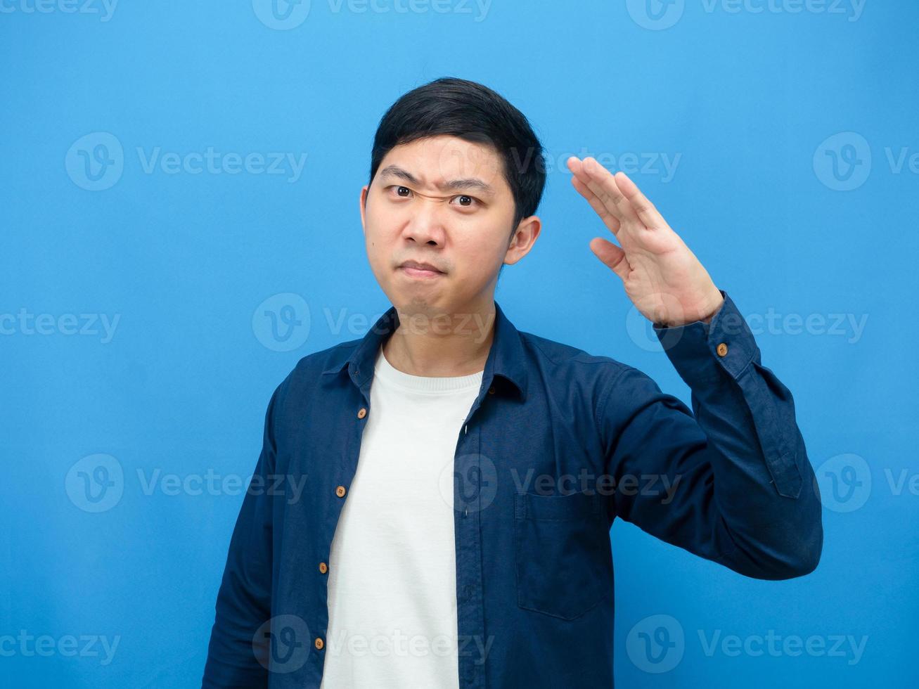 Mann zuversichtlich Gesicht Geste respektieren Hand wie Soldat blauer Hintergrund foto