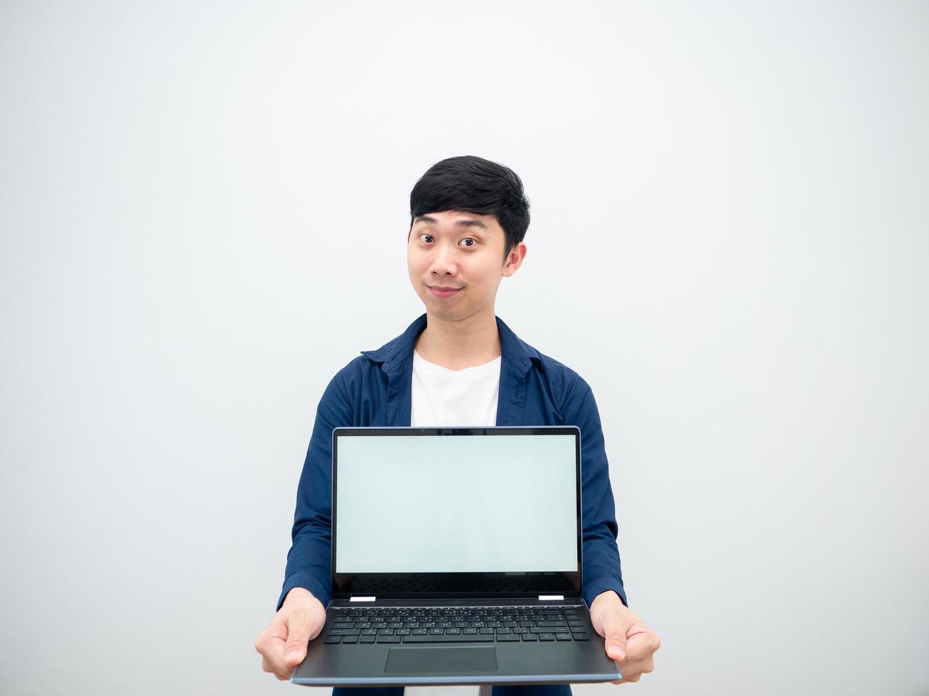 Asiatischer junger Mann zeigt Laptop in der Hand mit lächelndem Gesicht und fröhlich auf weißem, isoliertem Hintergrund foto