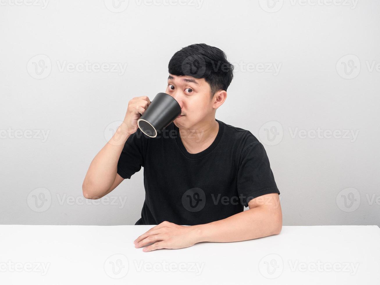 Mann sitzt und trinkt Kaffee am Tisch foto