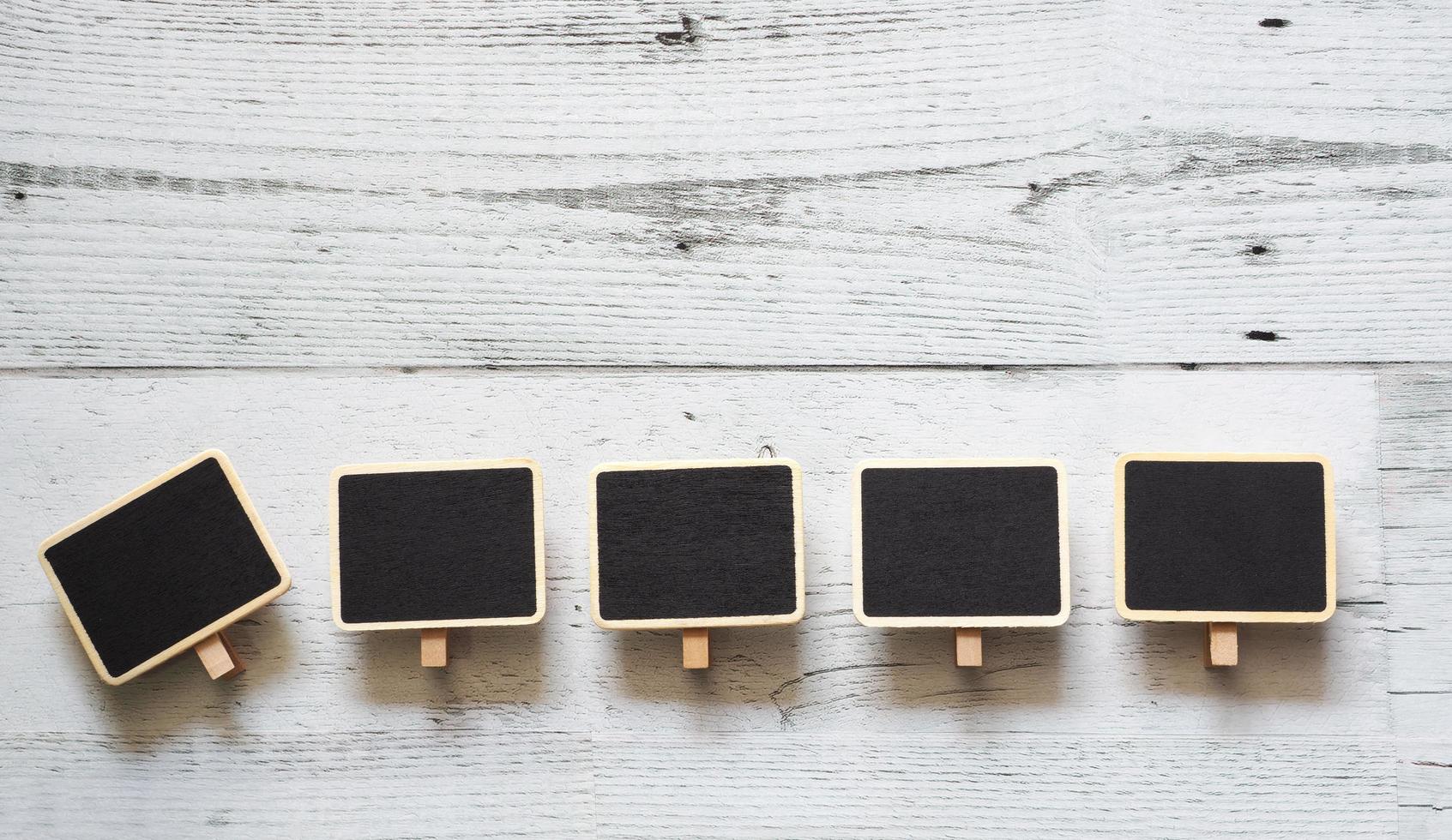 Fünf kleine Clip-Tafel-Array-Linie auf weißem Holztisch Naturschatten unter Raum, Idee-Schild-Konzept foto