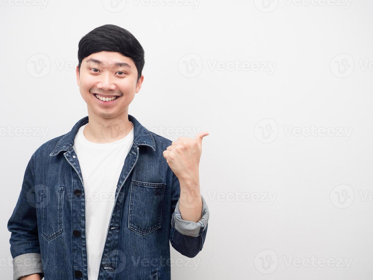 asiatischer mann jeanshemd lächelnde geste, die finger auf kopienraum zeigt foto