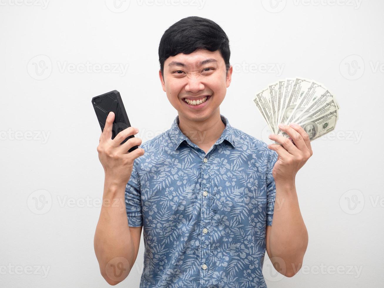 Mann fröhliches Lächeln mit Handy und viel Geld in der Hand foto