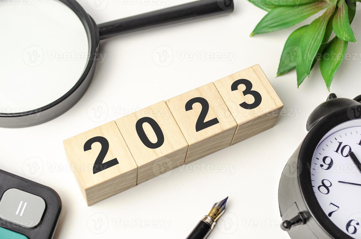 2023 Wort auf Holzblock mit und Wecker foto