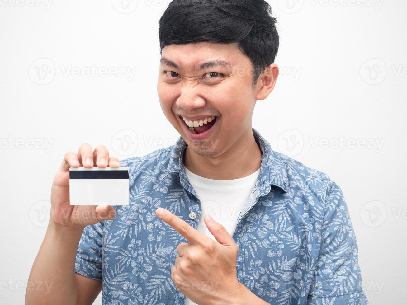 porträt asiatischer mann zeigt mit dem finger auf die kreditkarte in der hand glückliches lächeln emotion foto