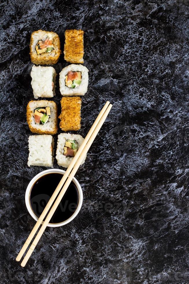 satz von sushi und maki auf steintisch. draufsicht mit kopierraum foto