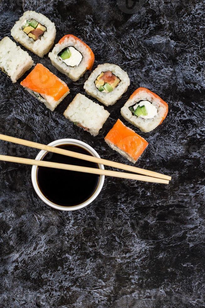 satz von sushi und maki auf steintisch. draufsicht mit kopierraum foto