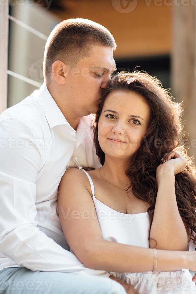 Porträt einer fröhlichen Frau und eines Mannes, die Zeit miteinander verbringen und draußen sitzen, sich auf der Sommerterrasse umarmen und lachen, verliebtes Paar am Valentinstag foto