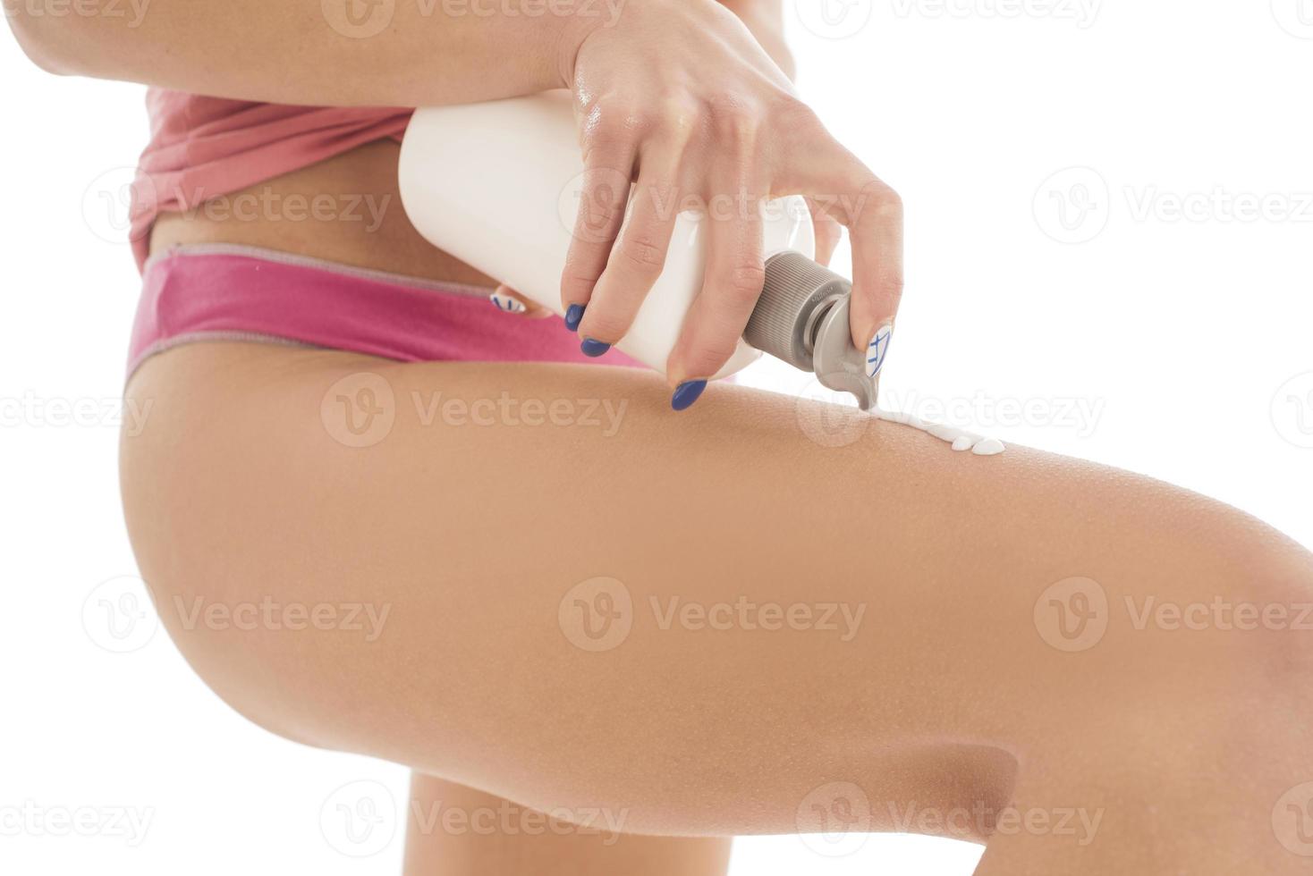 Körperpflege. Frau, die Creme auf die Beine aufträgt. Frau, die Anti-Cellulite-Creme aufträgt foto