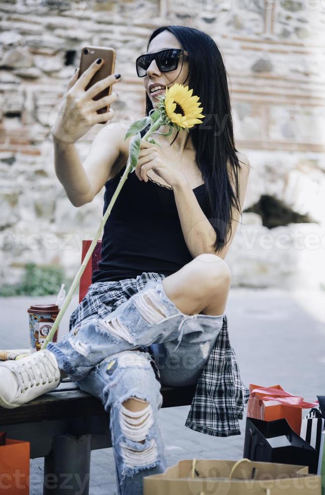 hübsches mädchen, das selfie mit einkaufstüten macht foto