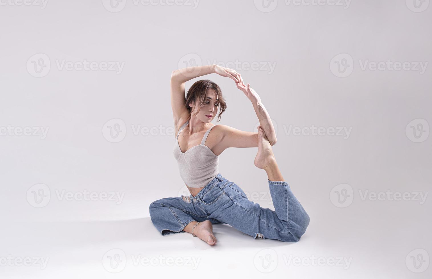 Porträt einer schönen jungen Frau mit athletischem, flexiblem Körper, die Beindehnung macht. isoliert foto