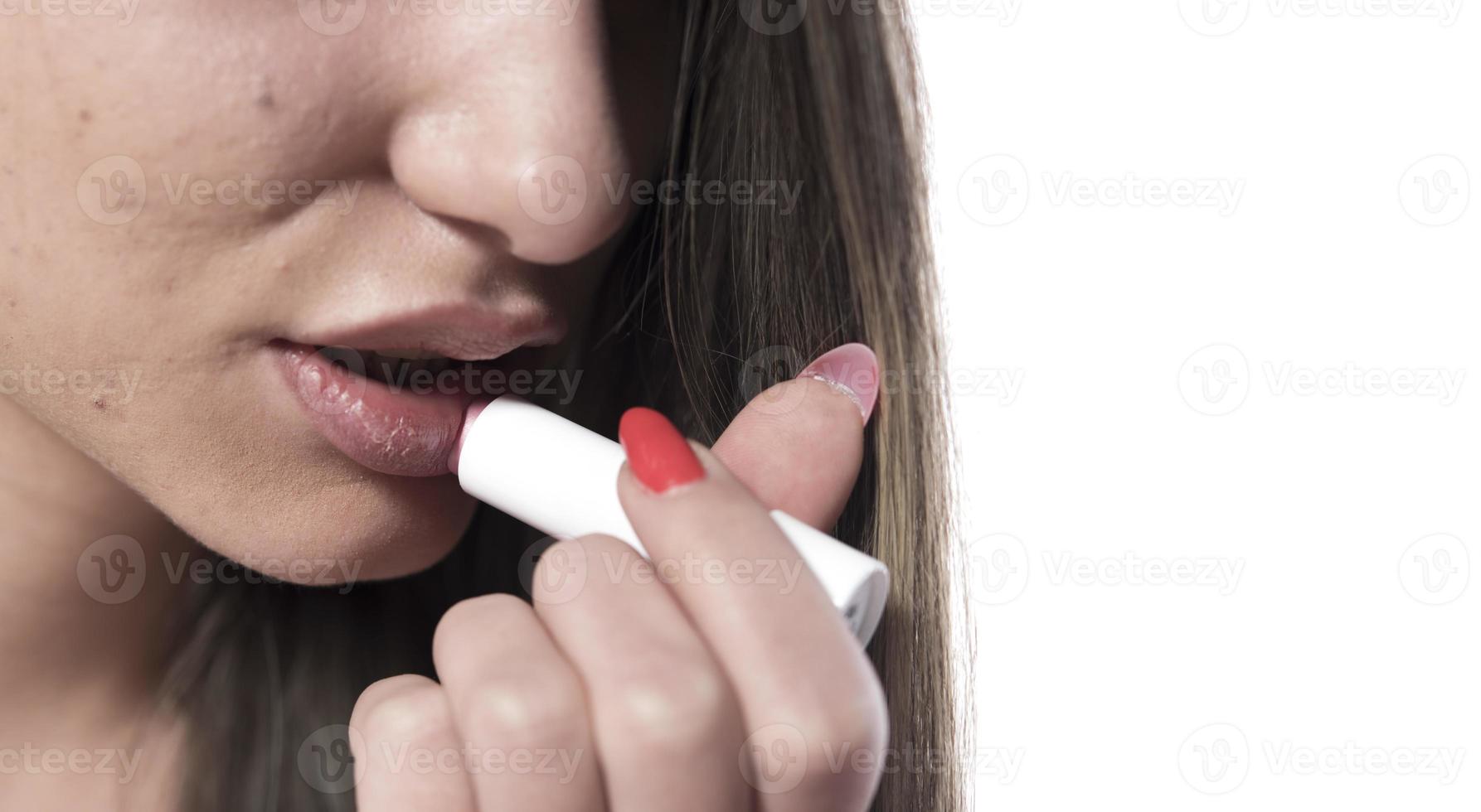 Lippenpflege. Schönes Frauengesicht mit sexy vollen Lippen, die hygienischen Lippenbalsam, Lippenpflegestift auftragen. nahaufnahme des weiblichen gesichts mit weicher haut, die den lippenschutz-lippenstift aufsetzt. Beauty-Kosmetik-Konzept foto