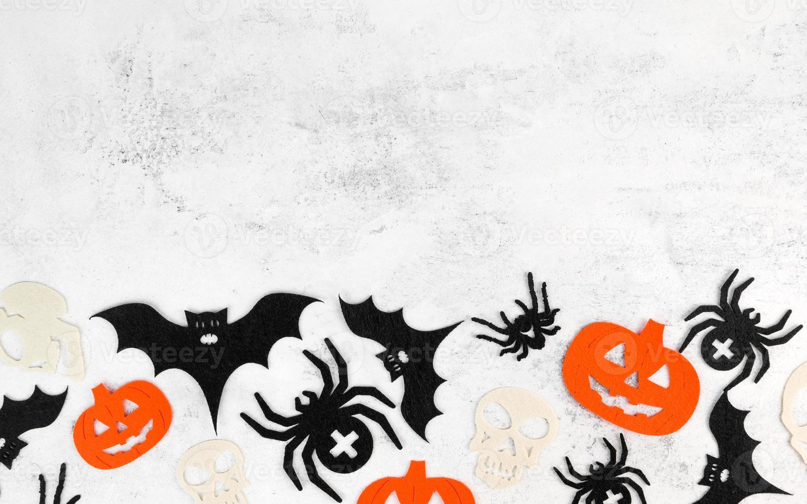 minimalistischer halloween-hintergrund mit schädel, kürbissen, fledermäusen und spinnen auf weißem betonhintergrund. einladung oder karte für den 31. oktober. kopieren sie platz foto