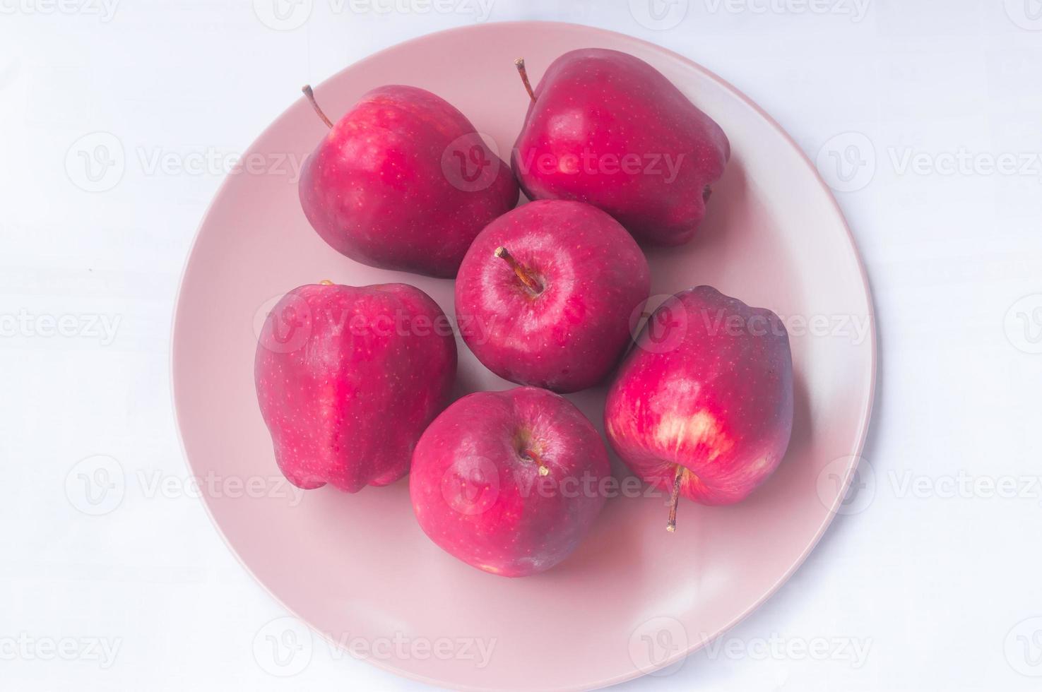 frische rote Äpfel in rosa Teller isoliert auf weißem Hintergrund foto