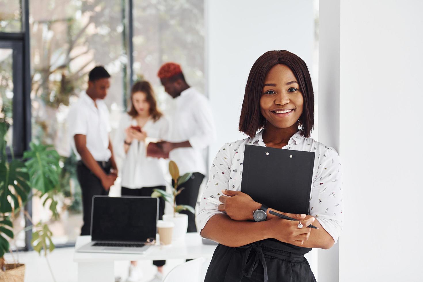 Frau mit Notizblock. gruppe afroamerikanischer geschäftsleute, die gemeinsam im büro arbeiten foto