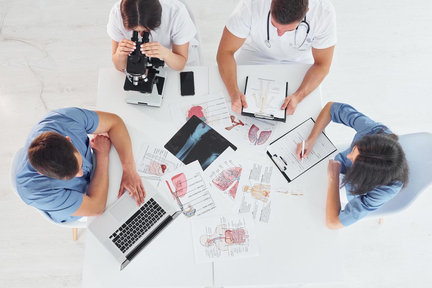 Ansicht von oben. Gruppe junger Ärzte arbeitet in der modernen Praxis zusammen foto