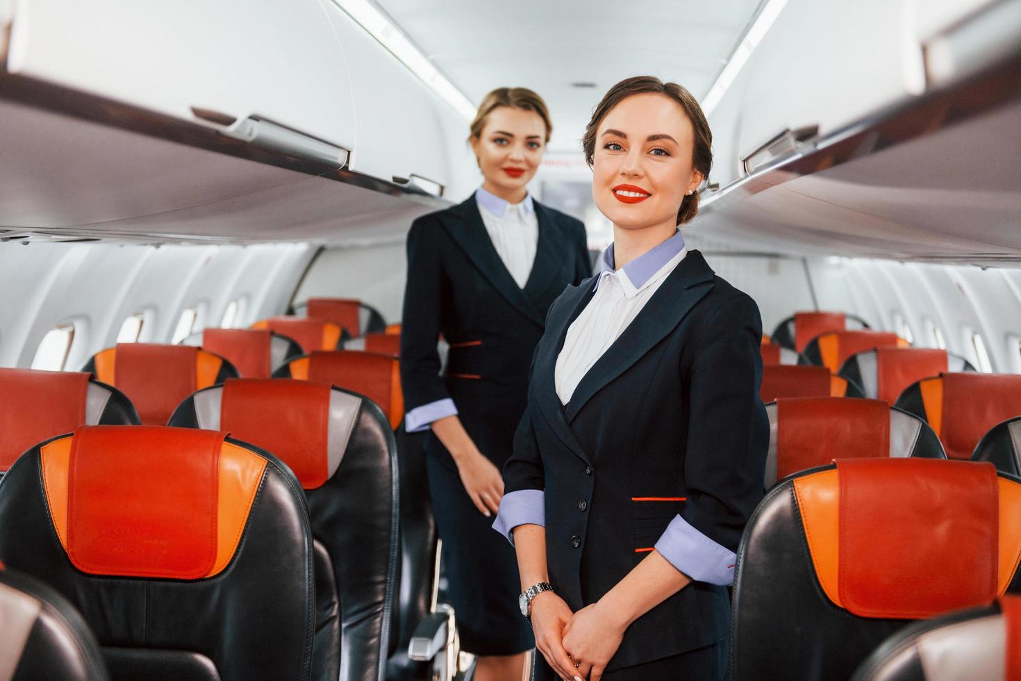 zwei Stewardess bei der Arbeit im Passagierflugzeug foto