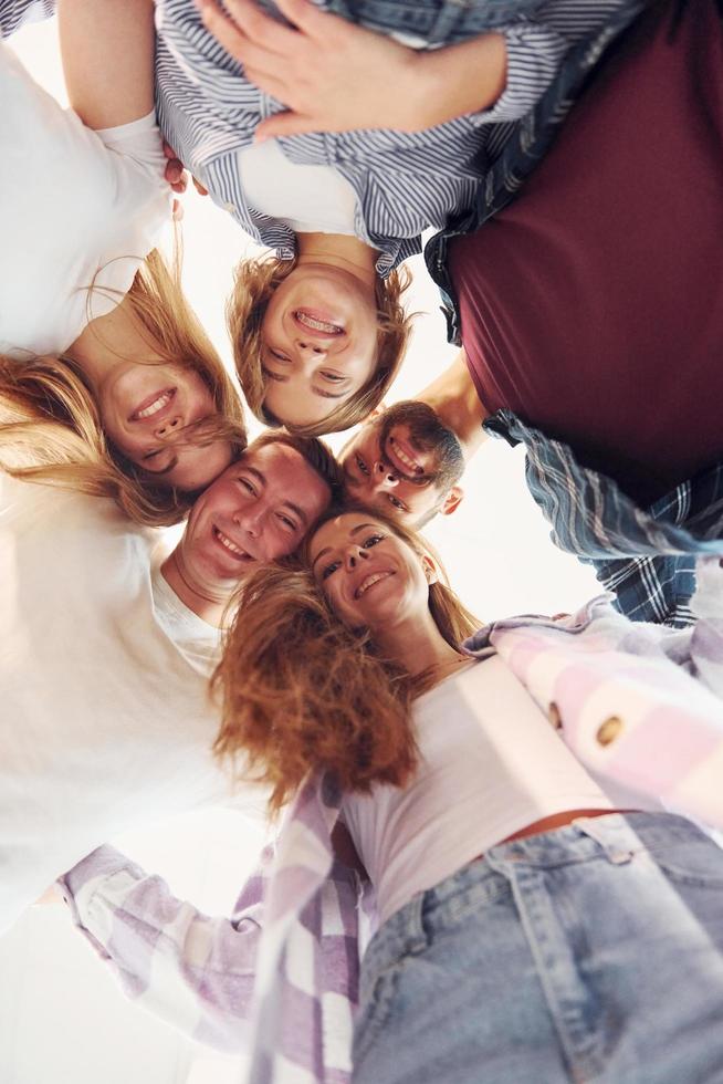 herunterschauen. Gruppe von Freunden, die zusammenstehen foto