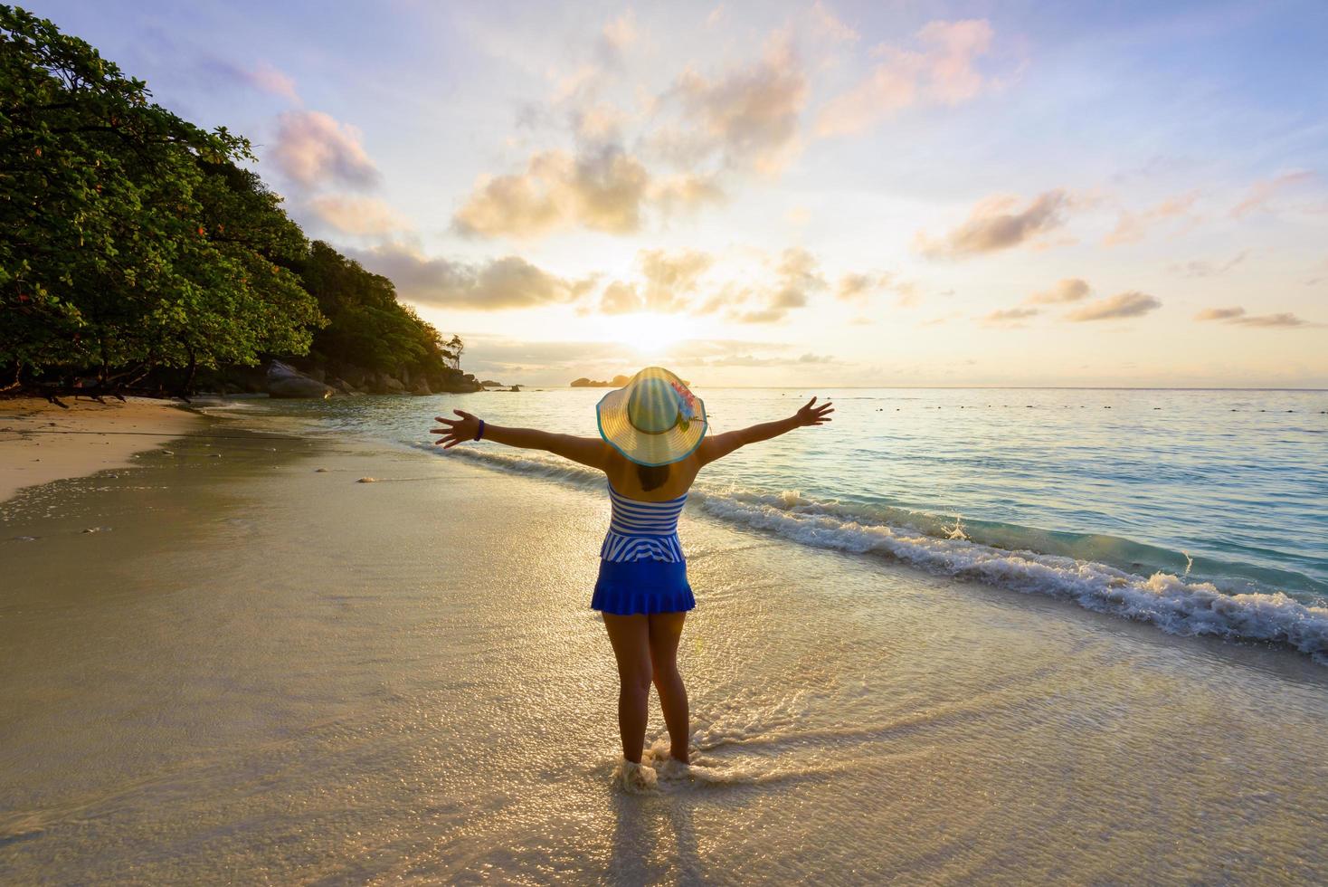 glückliches Mädchen am Strand bei Sonnenaufgang foto