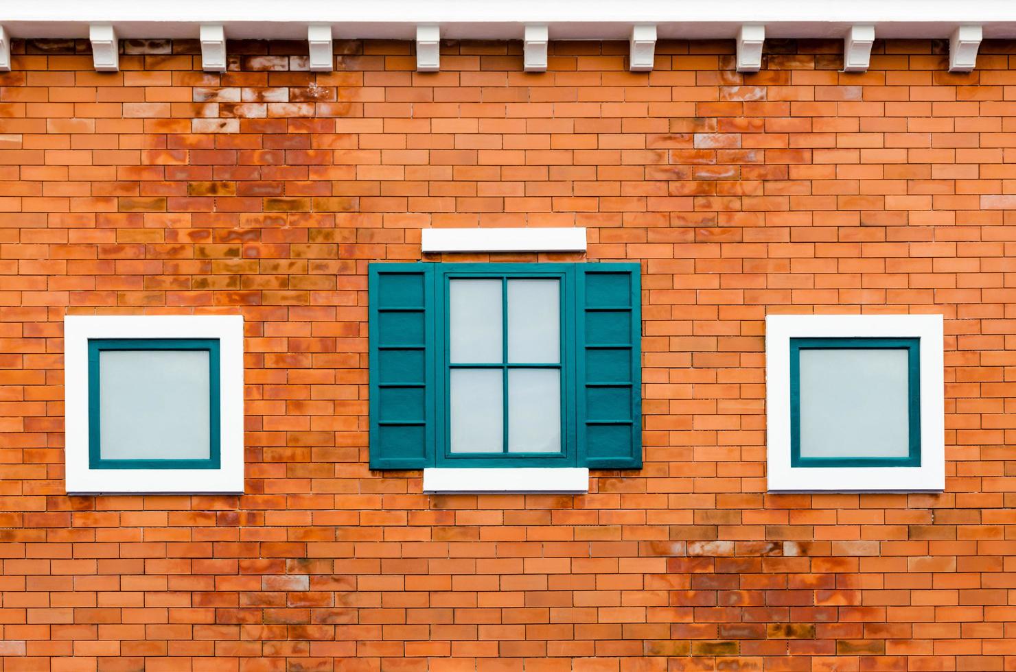 Fenster auf der orangefarbenen Backsteinmauer foto