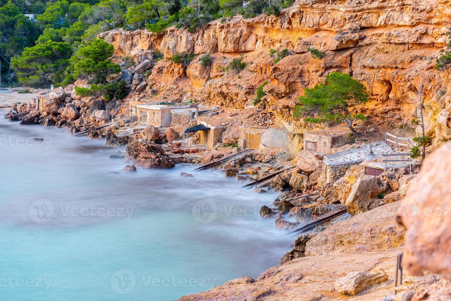 Cala Salada und Saladeta in San Antonio Abad auf den Balearen in Spanien. Langzeitbelichtung, typisches Haus für Fischerboote und Felsen. foto