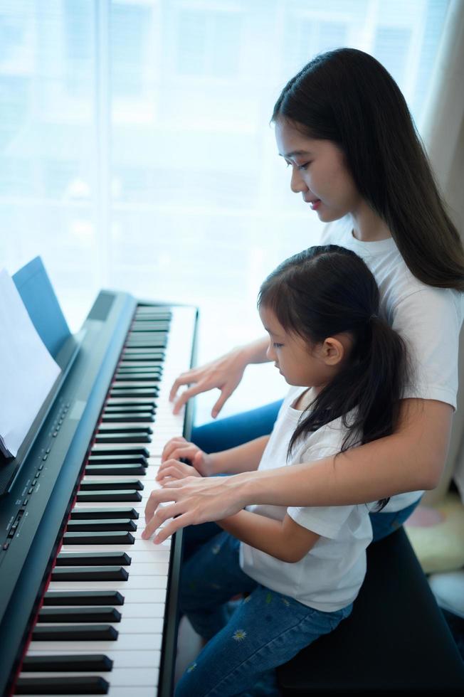 Familienurlaub, andere helfende Tochter üben in ihrem Klavierunterricht foto