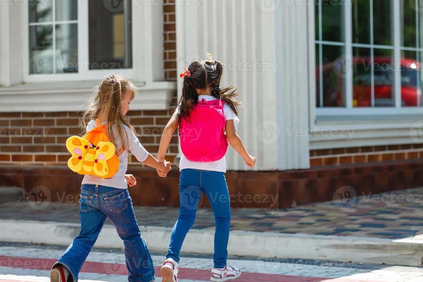 Zwei Schulmädchen gehen zur Schule. das konzept von schule, studium, bildung, freundschaft, kindheit. foto