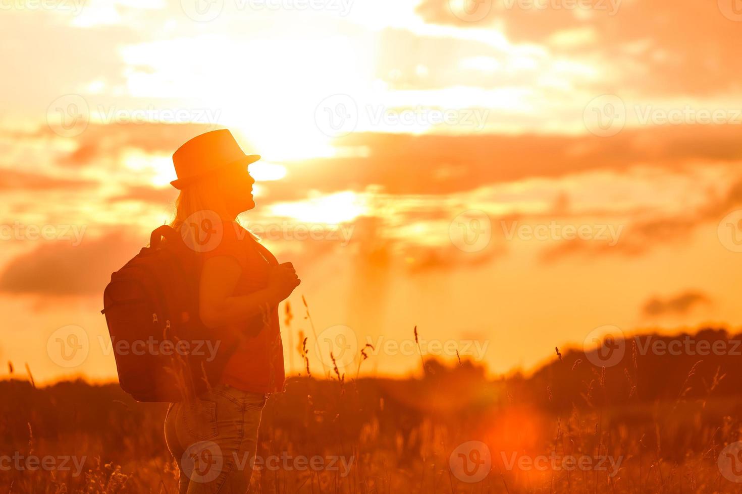 Frauensilhouette wartet auf Sommersonne auf der Wiese foto