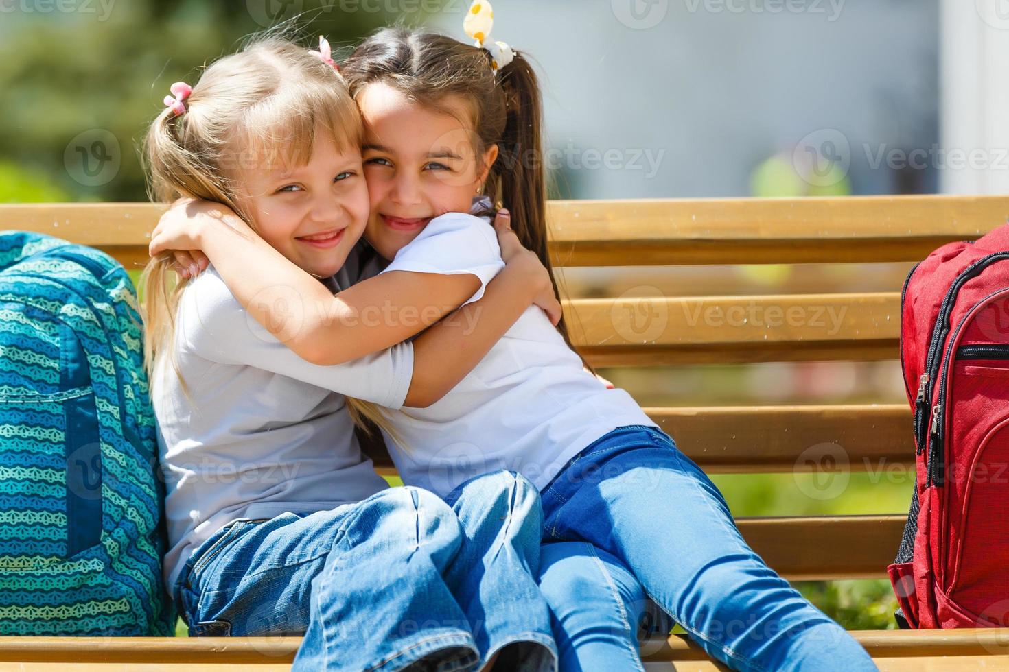 glückliche kleine mädchen mit klassenkameraden, die spaß in der schule haben foto