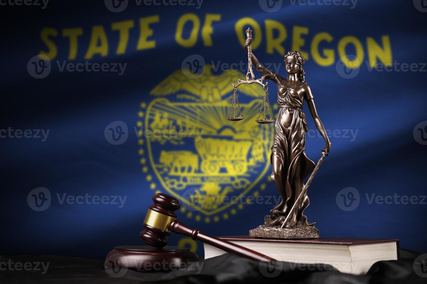 Oregon US-Staatsflagge mit Statue von Lady Justice, Verfassung und Richterhammer auf schwarzem Vorhang. Begriff von Urteil und Schuld foto