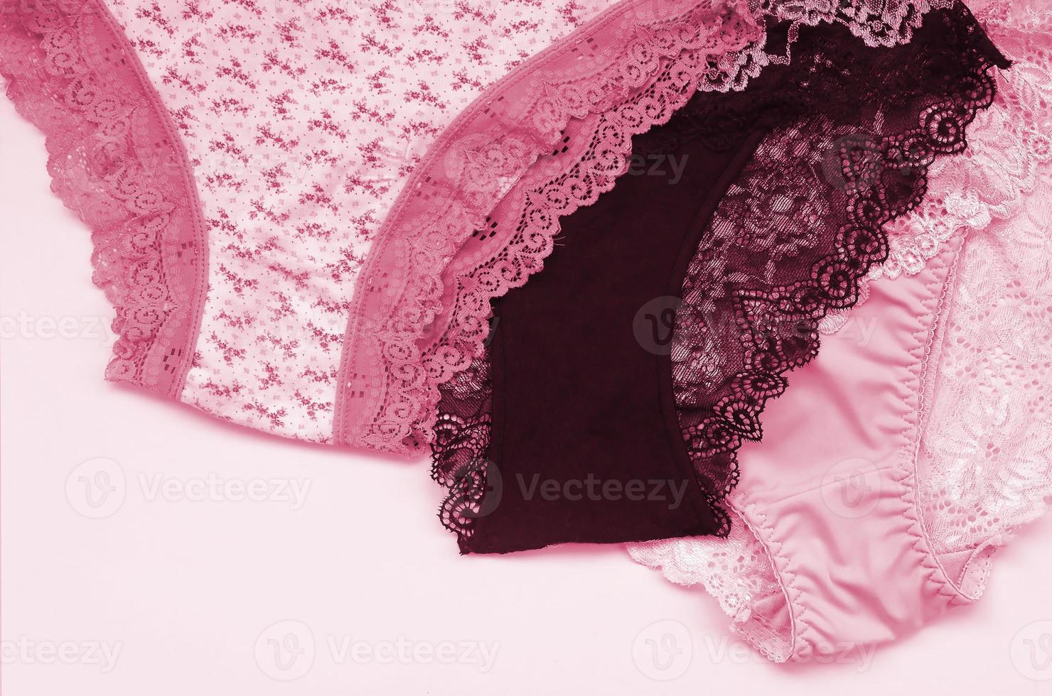 weiße, schwarze und rosa Damenunterwäsche mit Spitze auf rosa Hintergrund mit Kopierraum. Werbung für Shop of Beautiful Women Unterwäsche Bild getönt in Viva Magenta, Farbe des Jahres 2023 foto