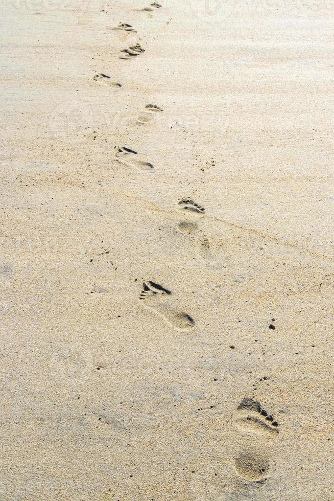 fußabdruck fußspuren auf dem strandsand am wasser mexiko. foto