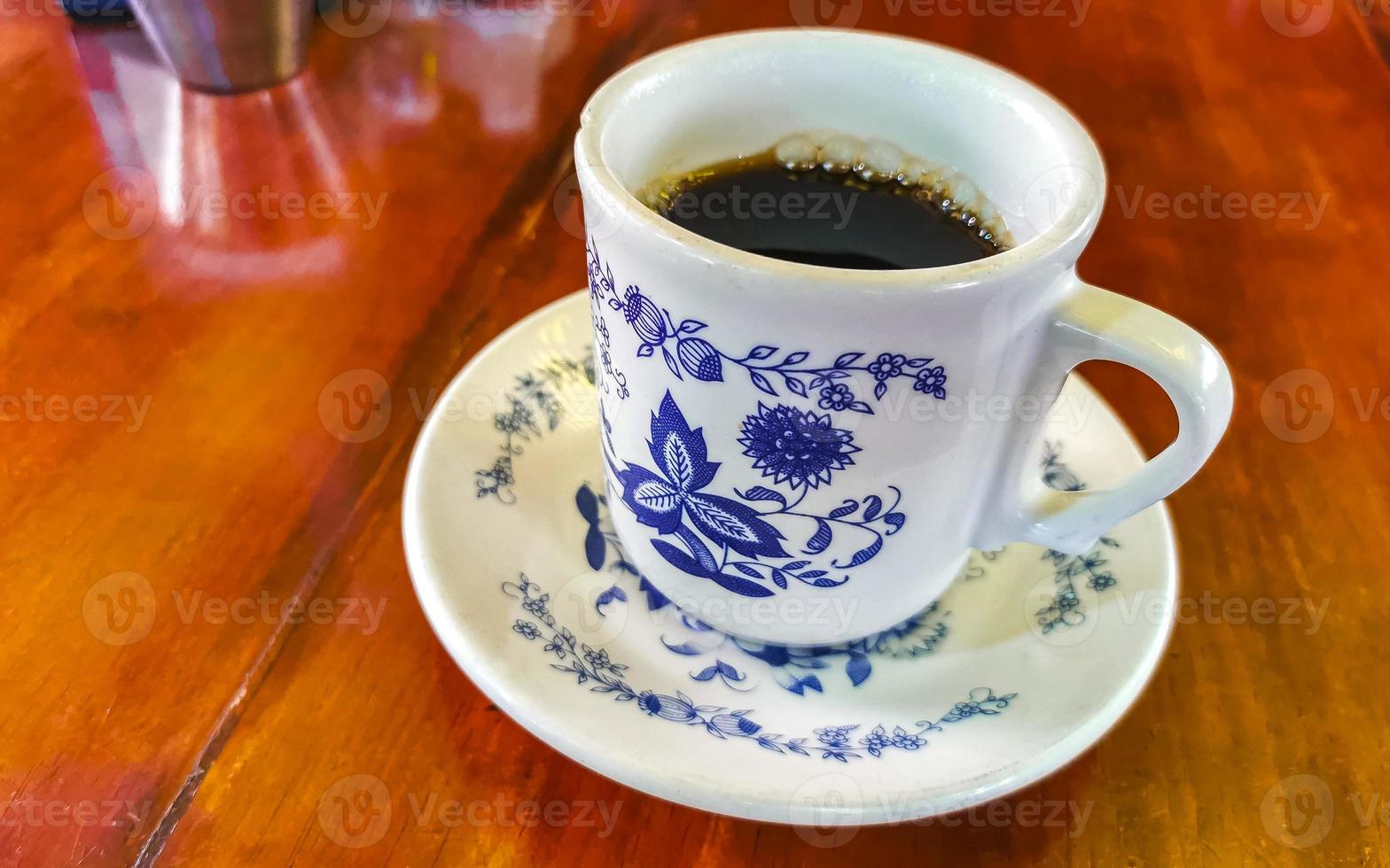 blauer weißer tassentopf mit schwarzem kaffeeholztisch mexiko. foto