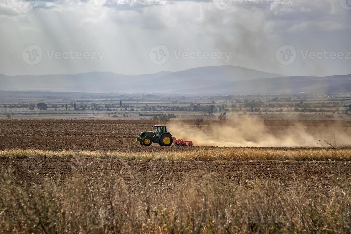 Der Traktor bereitet den Boden für die Aussaat und Bearbeitung vor. landwirtschafts- und agronomisches konzept. foto