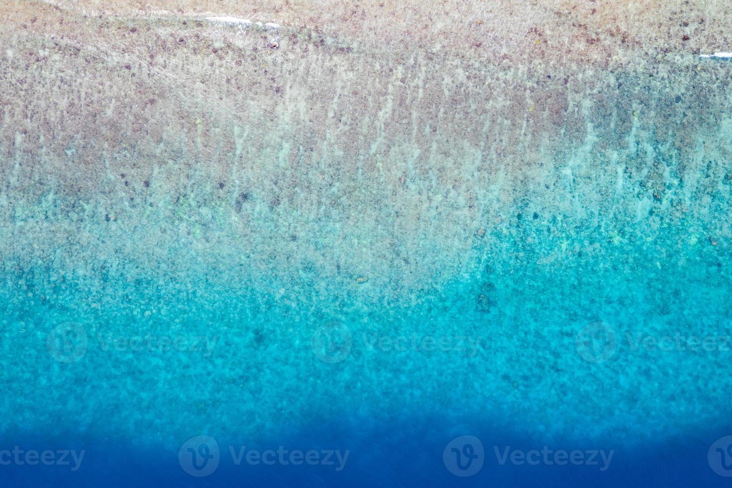 luftblick auf das meer, draufsicht auf den erstaunlichen naturozeanhintergrund. Hellblaue Wasserfarben, Lagunenstrand mit Wellen, die an sonnigen Tagen plätschern. fliegendes Drohnenfoto, erstaunliche Naturlandschaft mit Korallenriff foto