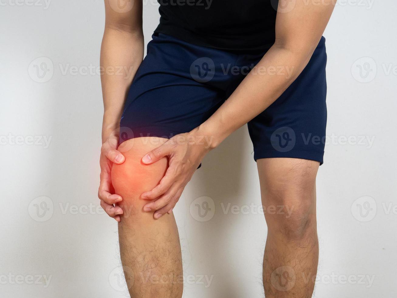 Der Mensch verletzte sich am Knie und hielt ihn mit der Hand auf weißem Hintergrund foto