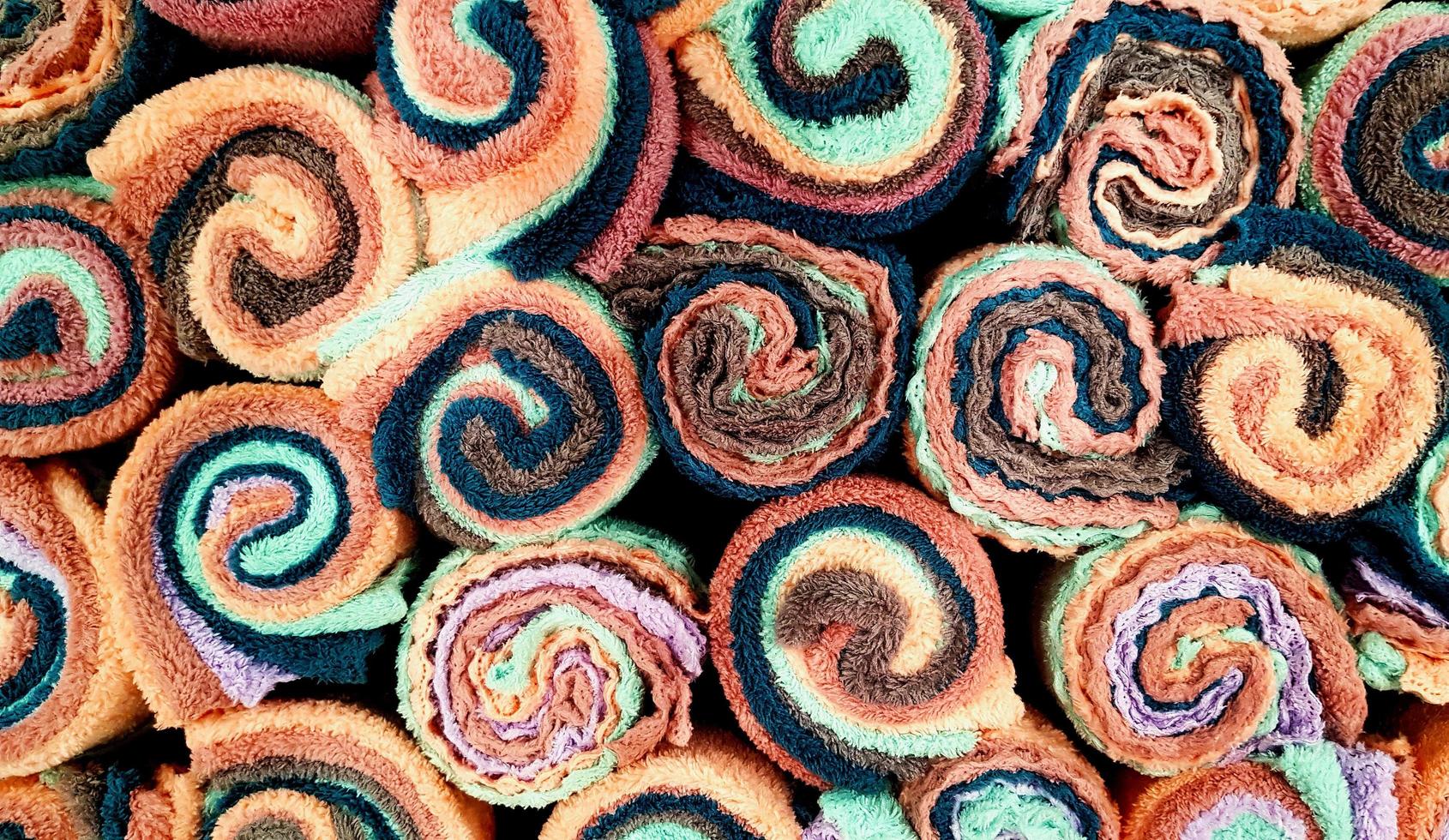 Draufsicht auf bunte Handtücher oder Handtücher für den Hintergrund. strukturiertes muster aus baumwolle oder stoffwand. Kunstfarbtapete und Form des Objekts. foto