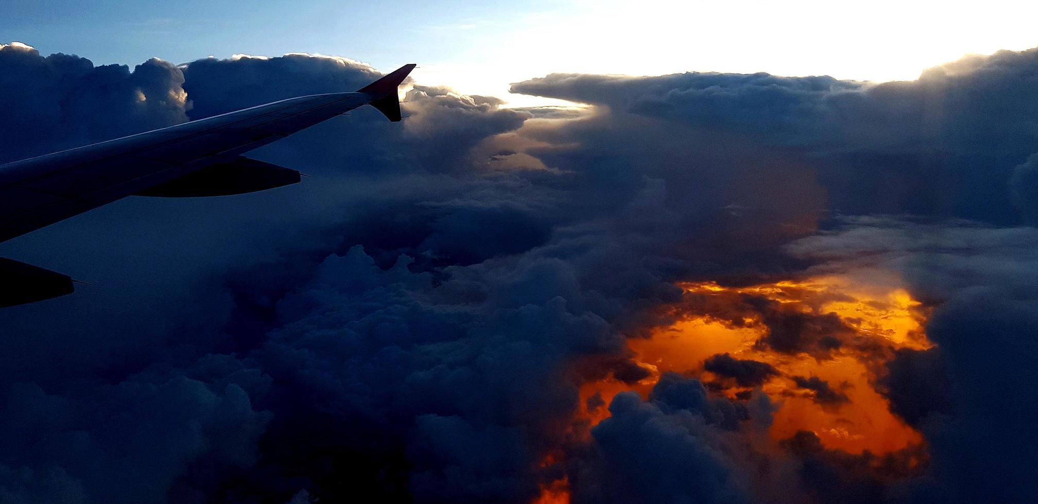 Silhouette von Flugzeugen oder Flugzeugflügeln auf dunklem Himmel und Wolke mit Sonnenuntergang, hellem Hintergrund mit Kopierraum. Transport, Reisen und Schönheit der Natur oder Natur. foto