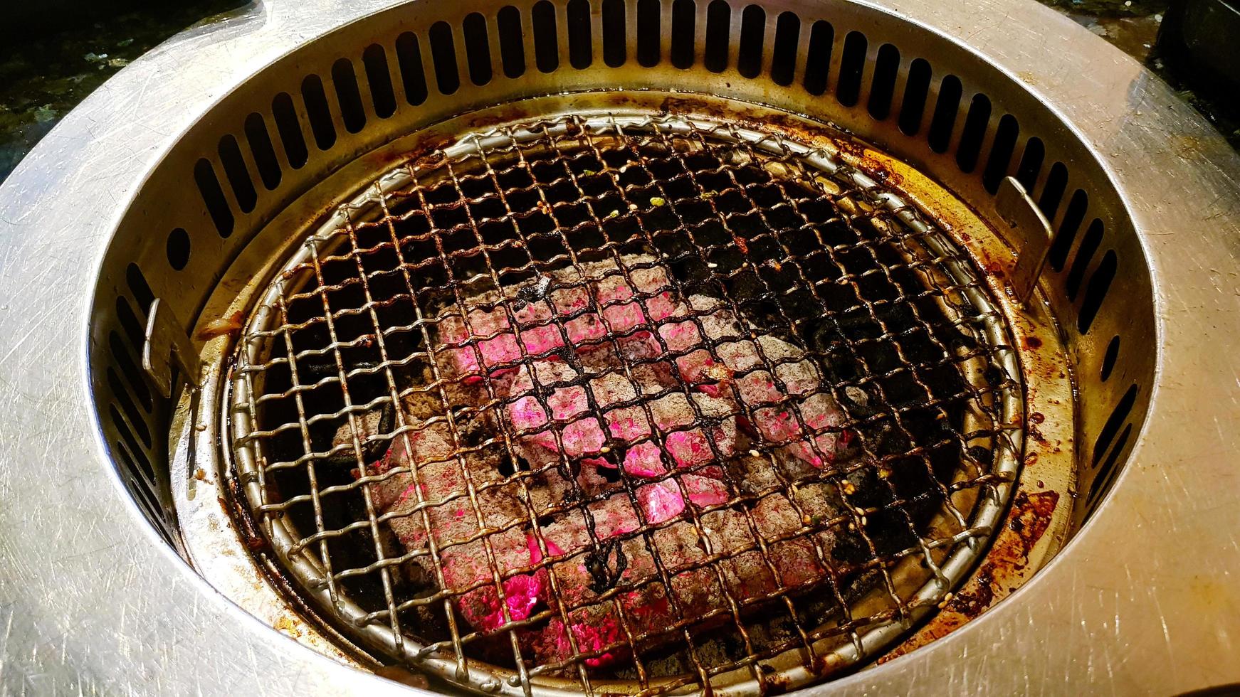 Holzkohlegrillofen mit Edelstahlnetz zum Grillen in koreanischen Restaurants. Geräte zum Kochen oder Zubereiten von Speisen. foto