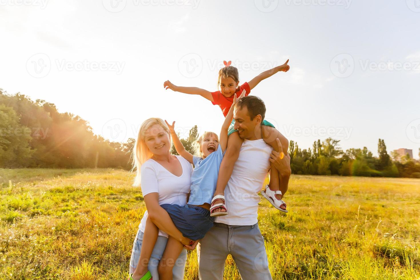 junge familie, die durch ein gelbes feld läuft foto