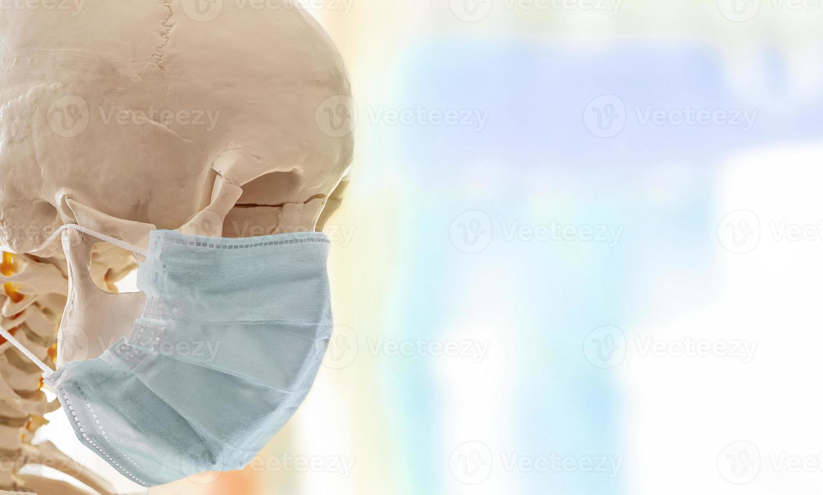 menschlicher schädel in einfacher dünner medizinischer maske zum schutz vor virusinfektionen foto