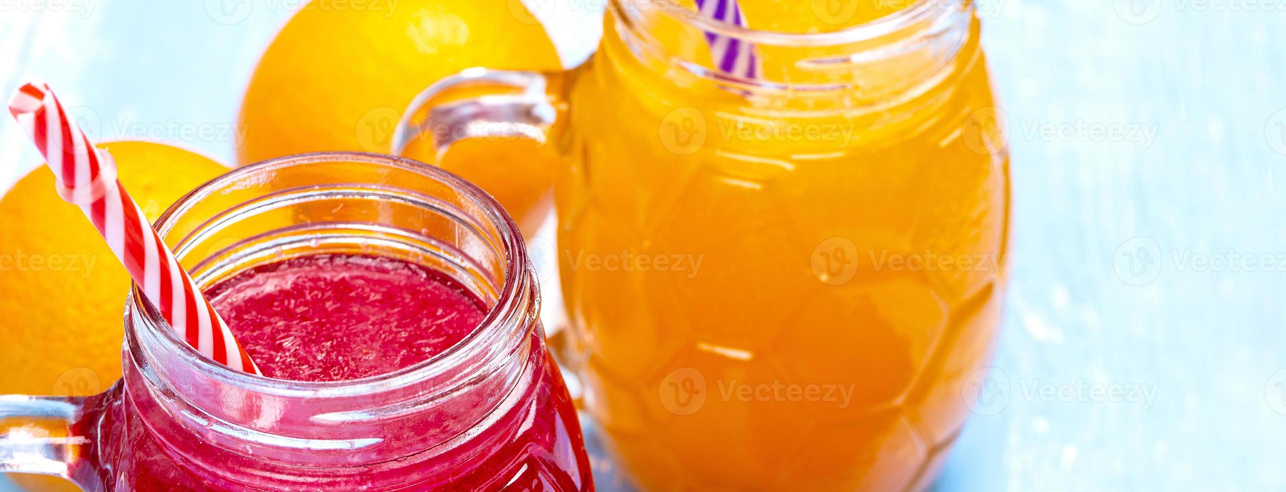 Orangen- und Erdbeersaft auf blauem Holztisch foto